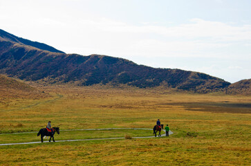 Fototapeta na wymiar Horseback Riding and Stunning Scenery at Mt. Aso national park in Kyushu, Japan.