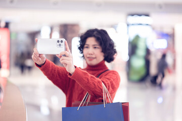 Woman taking selfie while shopping in mall