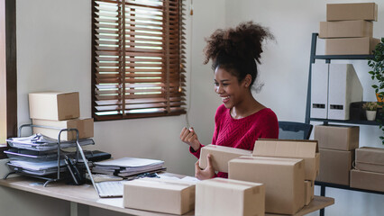 African american women raise arm to celebrate with happiness while checking online order on laptop