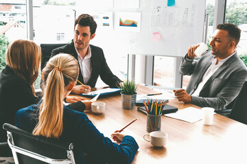 Businessman executive in group meeting discussion with other businessmen and businesswomen in...