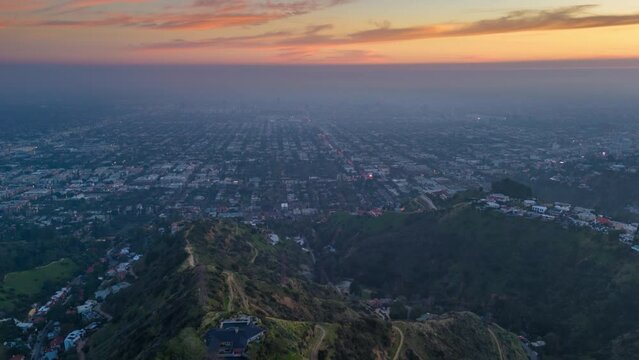 City of Los Angeles cityscape panorama at sunset, scenic overlook from Hollywood Hills. Aerial hyperlapse timelapse.