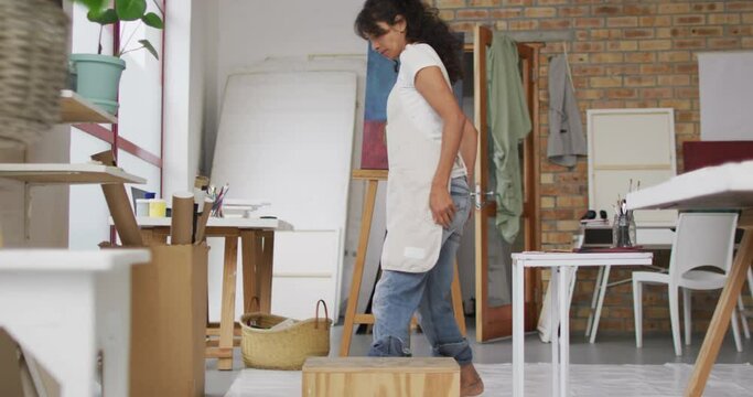 Artist prepares her workspace in a bright art studio