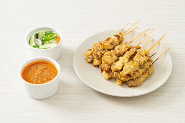 Pork satay with peanut sauce pickles which are cucumber slices and onions in vinegar