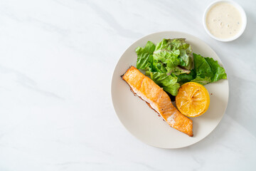 fried salmon steak with lemon and vegetable