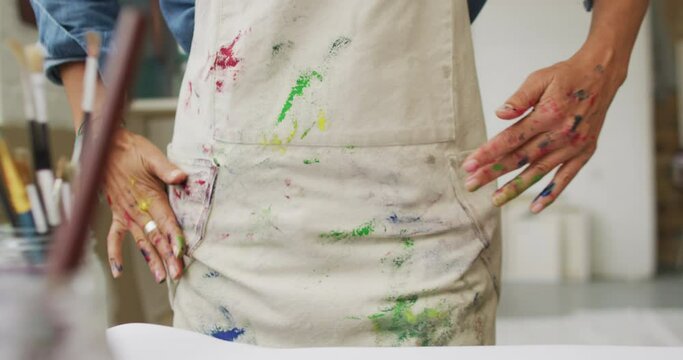 Artist shows off paint-covered hands in a creative studio