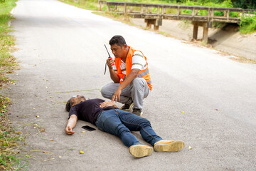 A rescue workers using radio communication calling for help team ะo help a man lying unconscious...