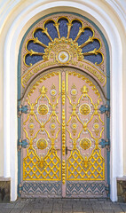 A gilded door decorated with exquisite carvings, the entrance to one of the boundaries of the Pochaev Lavra. View Pochaev Lavra to Pochaev, a city in western Ukraine.