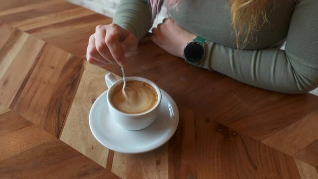 Overhead view of a woman's hand with a coffee cup 