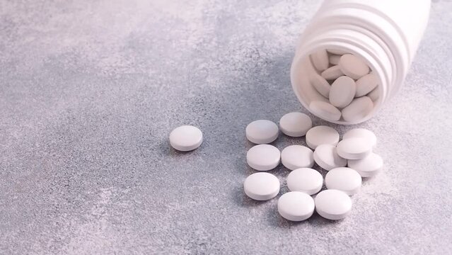 Pour the white pills out of the vials. The concept of health, treatment. Medicines and vitamins. Close-up