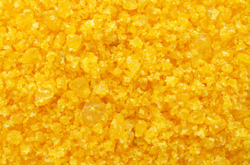 Pile of yellow sea salt background, top view. Aromatic bath salts with mango scent, close-up, for background, top view. The surface is covered with yellow salt crystals as a background.