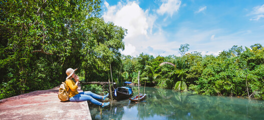 Asian woman travel nature. Travel relax.a boat photo. Sitting watching the beautiful nature at tha pom-klong-song-nam. Krabi, in Thailand.