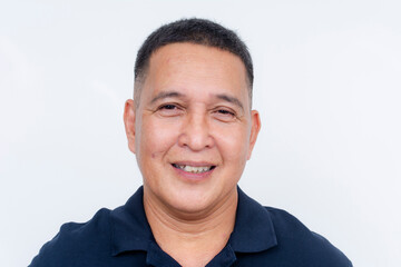 A cheerful middle-aged Asian man in a casual polo shirt smiles warmly, isolated on a pure white...