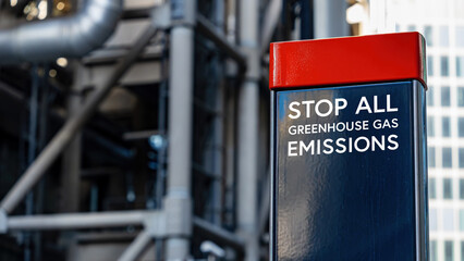 Stop all Greenhouse Gas Emissions on a sign in front of an Industrial building	
