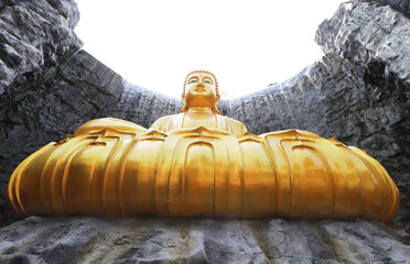 The big golden Buddha statue with waterfall and stone wall in background at Wat Lak Si Rat Samoson, Samut Sakhon, Thailand.