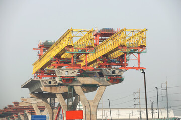 Machinery for placing precast segments over columns for the deck of elevated road.