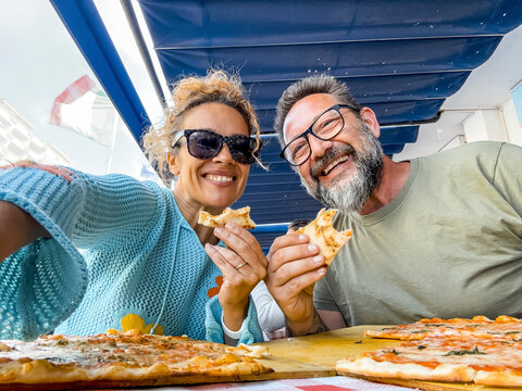 Smiling couple enjoy lunch at pizzeria. Beautiful smiling couple taking selfie and having fun in pizza, having fun together. Consumerism, food, lifestyle concept