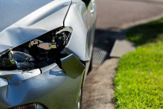 Smashed and dented side and headlight of car