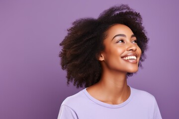 Happy african american young woman with afro hairstyle on purple background