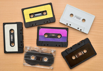 Old cassette tapes collection on the brown wooden table. Vintage technology concept. Top view.