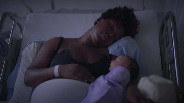 Black Woman with Curly Hair Resting in Delivery Room With Infant Child