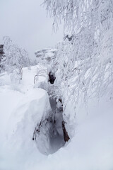 Fototapeta na wymiar Narrow path through snow drifts between rocks