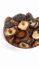 a pile of shiitake mushrooms in a container on a white background