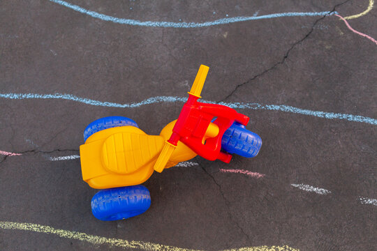 Toddlers tricycle on driveway with chalk bike track drawn on concrete