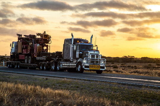 Semi trailer truck driving at dusk on Eyre Highway along the Nullarbor Plain