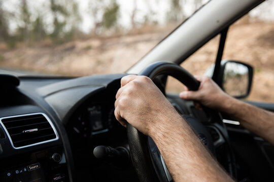 hands on a steering wheel on a highway drive