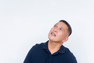 An Asian man in a dark polo shirt looks up to his left, displaying a curious and thoughtful...