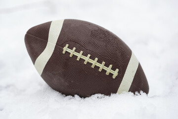 a football covered with snow and laying in the snow