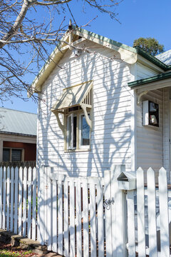 winter tree shadows on white weatherboard house