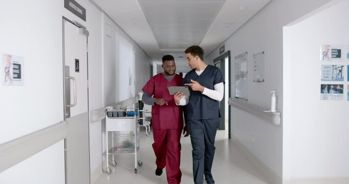 Diverse healthcare professionals discuss in a hospital corridor