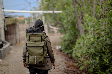 A man carrying a backpack walks in the forest