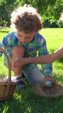Two children boy and girl having easter egg hunt in garden backyard