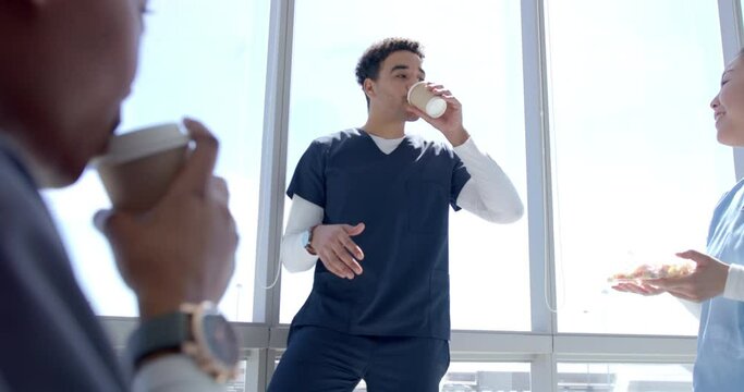 Young biracial healthcare worker enjoys a coffee break at the hospital