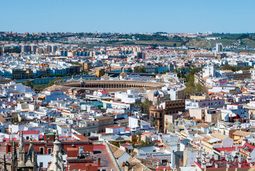 view over the roofs of Seville with the Plaza de Toro of the Royal Maestranza of Seville in the...