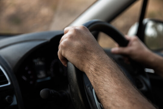 close up of driver hands on a steering wheel