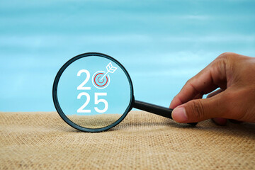 Magnifying glass and targets 2025. Concept of new year 2025, beginning of success, challenge or career path, change, planning, goals, challenges and new year resolutions.