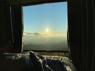 Morning View Through Wooden Window Overlooking Beach and Ocean Landscape with Open Sky and Sunlight Streaming into Bedroom