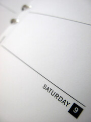 Empty diary page with binder - shallow depth of field - focus is on the date Saturday 9