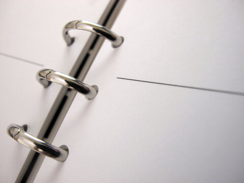 Empty diary page with binder - shallow depth of field with focus on three binder rings.