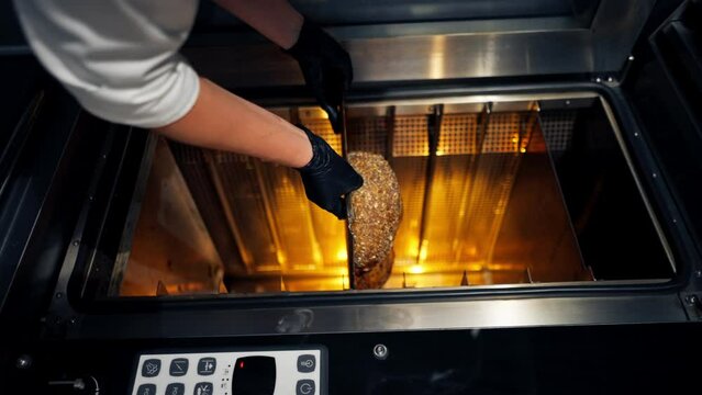 Close-up shot of hot freshly baked bread standing on baking tray and being finished in the oven on