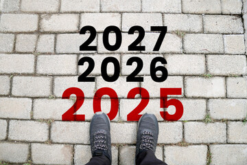 Start of new year. The text 2025 is written on the brick road and the male runner. Changes of year...