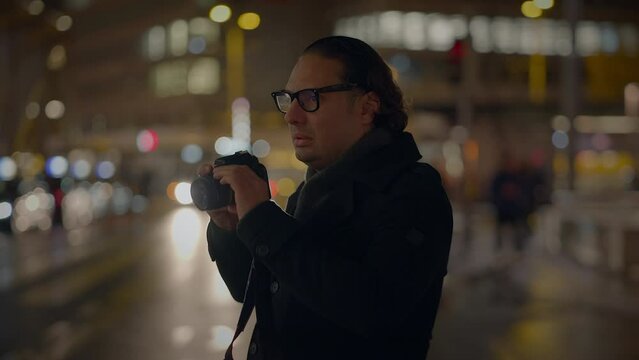 Male Traveler Taking Photo on Crowded Urban City Street at Night