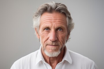 Portrait of a senior man with grey hair. Isolated on grey background.