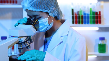 Scientists are doing research in a science lab. A medical chemist in a white coat, gloves and...