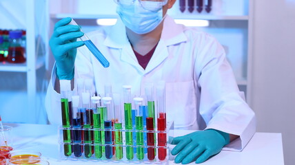 Scientists are doing research in a science lab. A medical chemist in a white coat, gloves and...