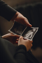 Close up photo of pregnant woman and her husband holding the ultrasound picture. Family concept