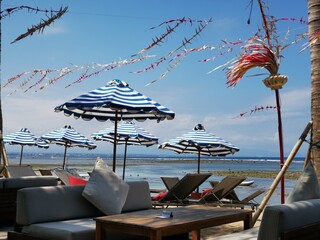 Five striped umbrellas on the beach, Bali.